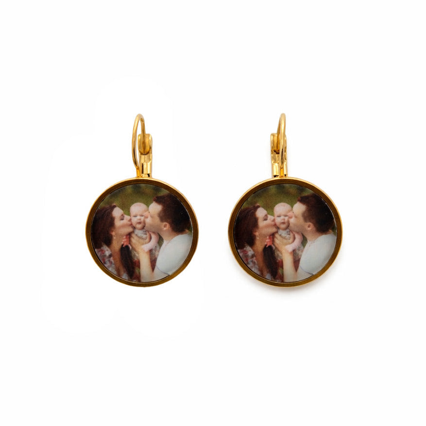 Gold earrings with circular designs on a white background
