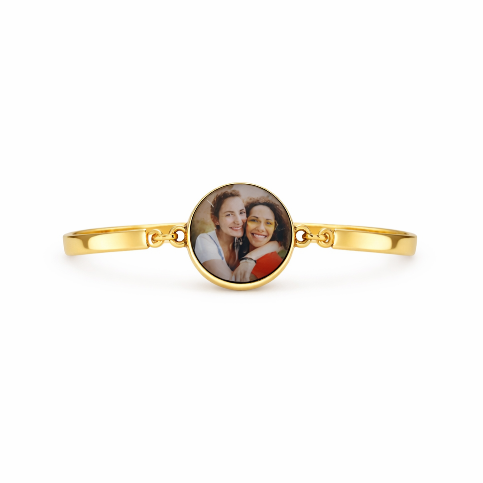 Gold bracelet with a round photo charm featuring two people on a white background