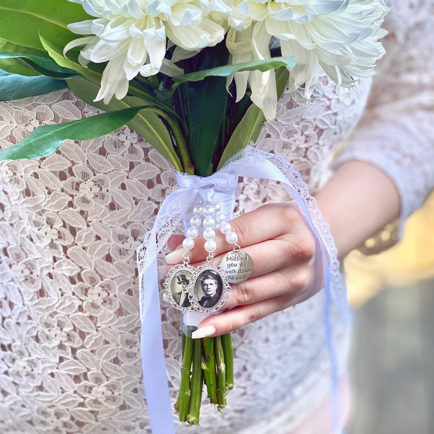 bridal bouquet charms with white pearls and personalised with photos. in hands of a bride. with floral bouquet