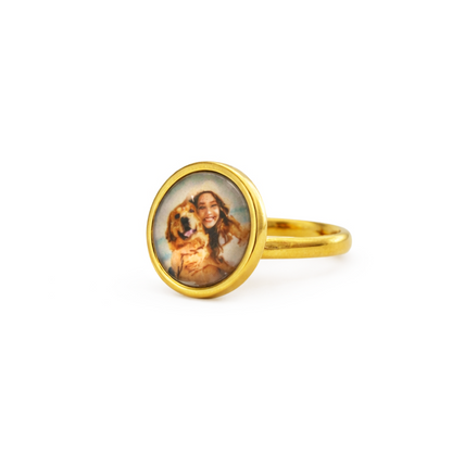 Gold ring with a circular pendant featuring a portrait on a white background