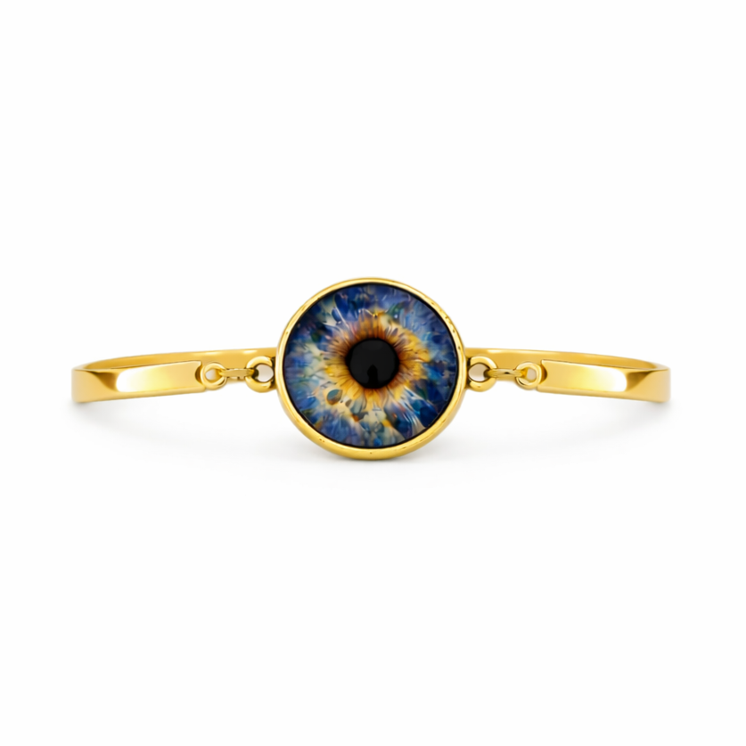 Gold bracelet with a blue and black eye design on a white background