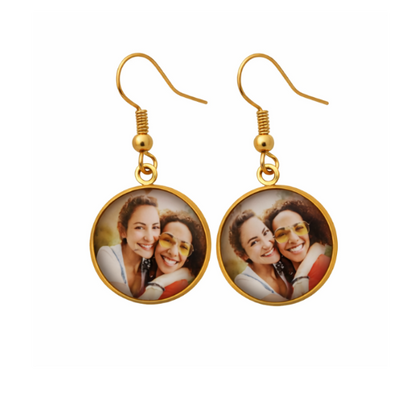 Gold earrings with circular charms featuring a photo of two women on a white background