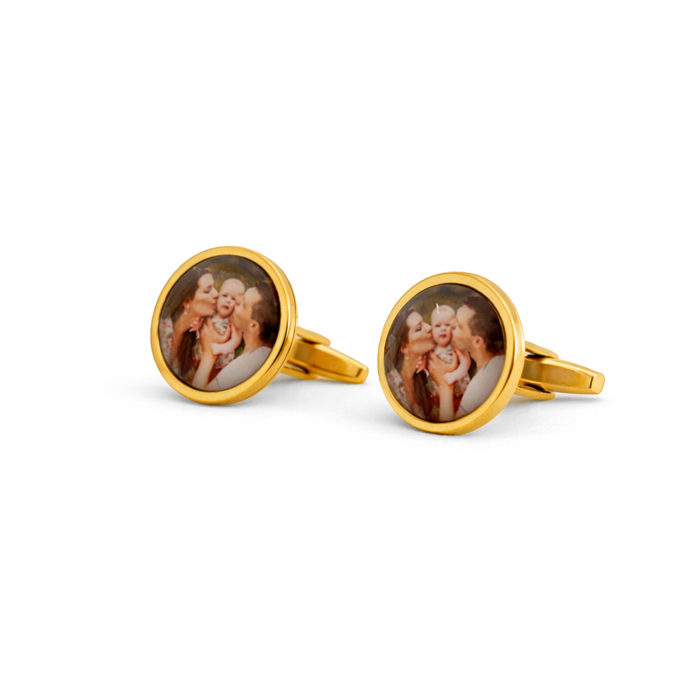 Gold cufflinks with circular designs on a white background