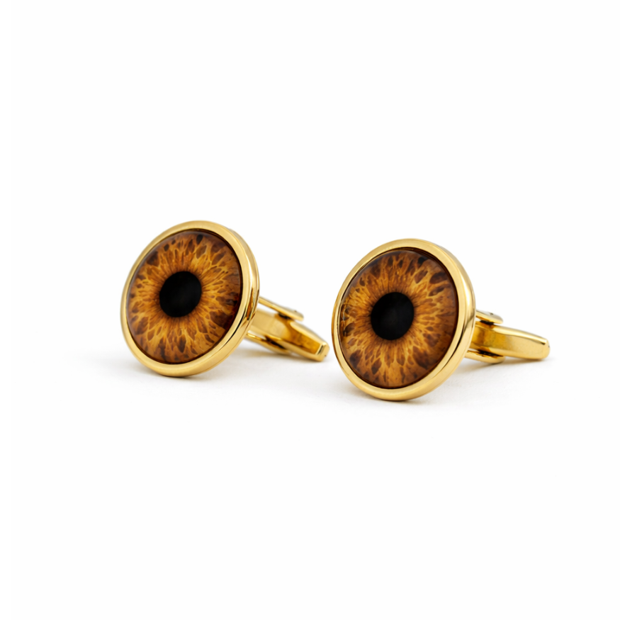 Gold cufflinks with eye design on a white background