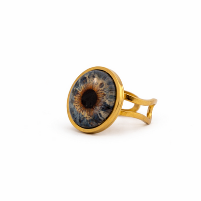Gold ring with a blue and brown eye design on a white background