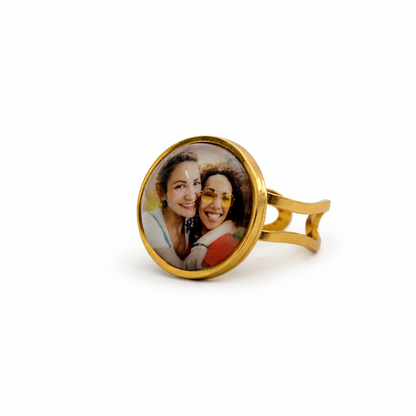 Gold ring with a circular photo insert on a white background