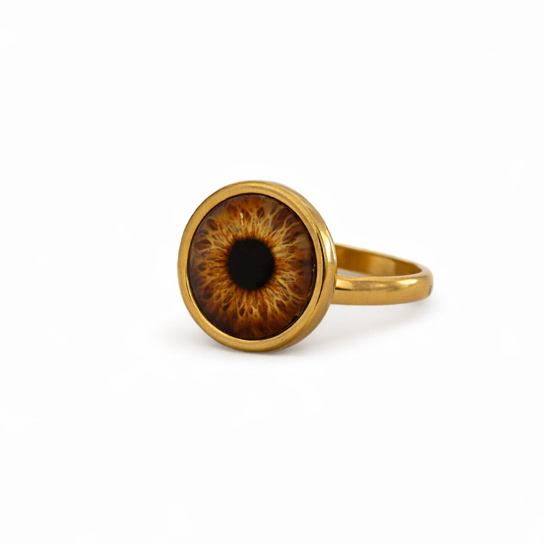 Gold ring with an eye-shaped design on a white background