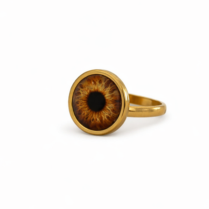 Gold ring with an eye-shaped design on a white background