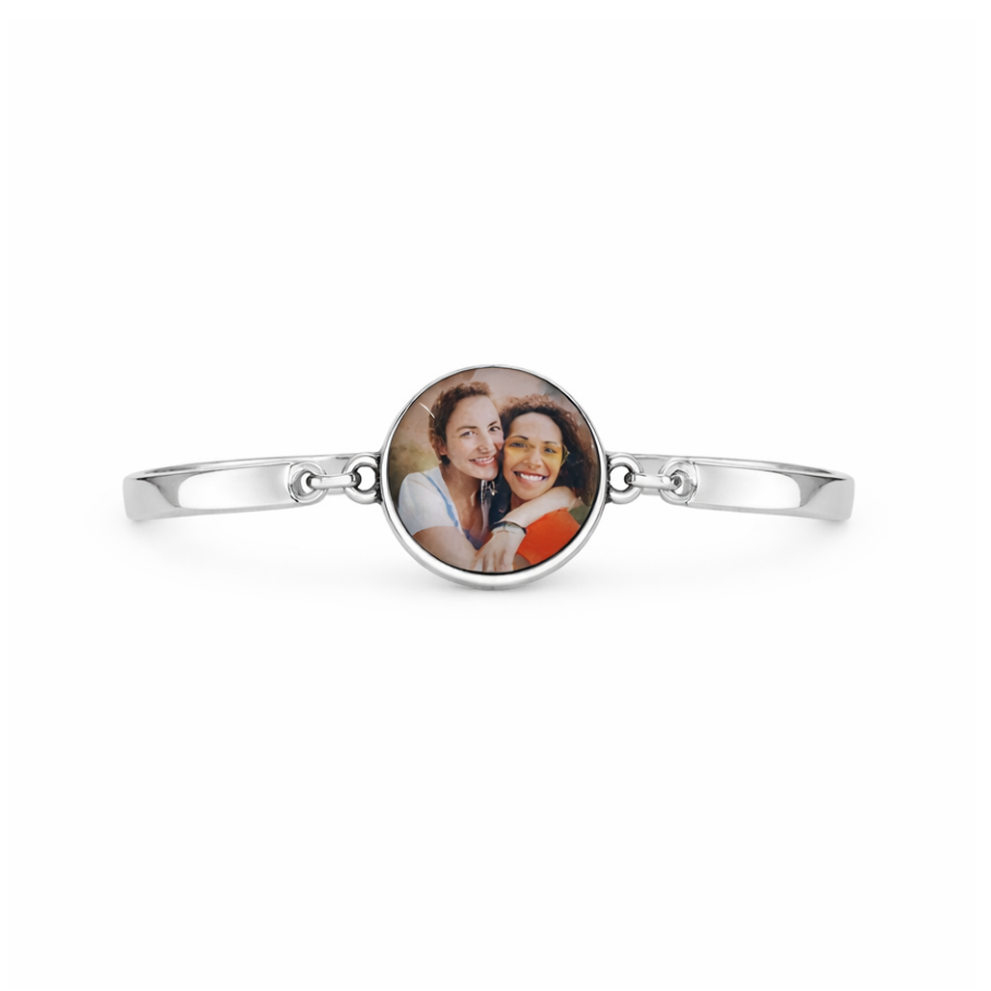 Silver bracelet with a round photo charm featuring two people on a white background