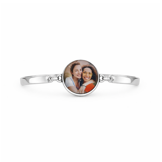 Silver bracelet with a round photo charm featuring two people on a white background